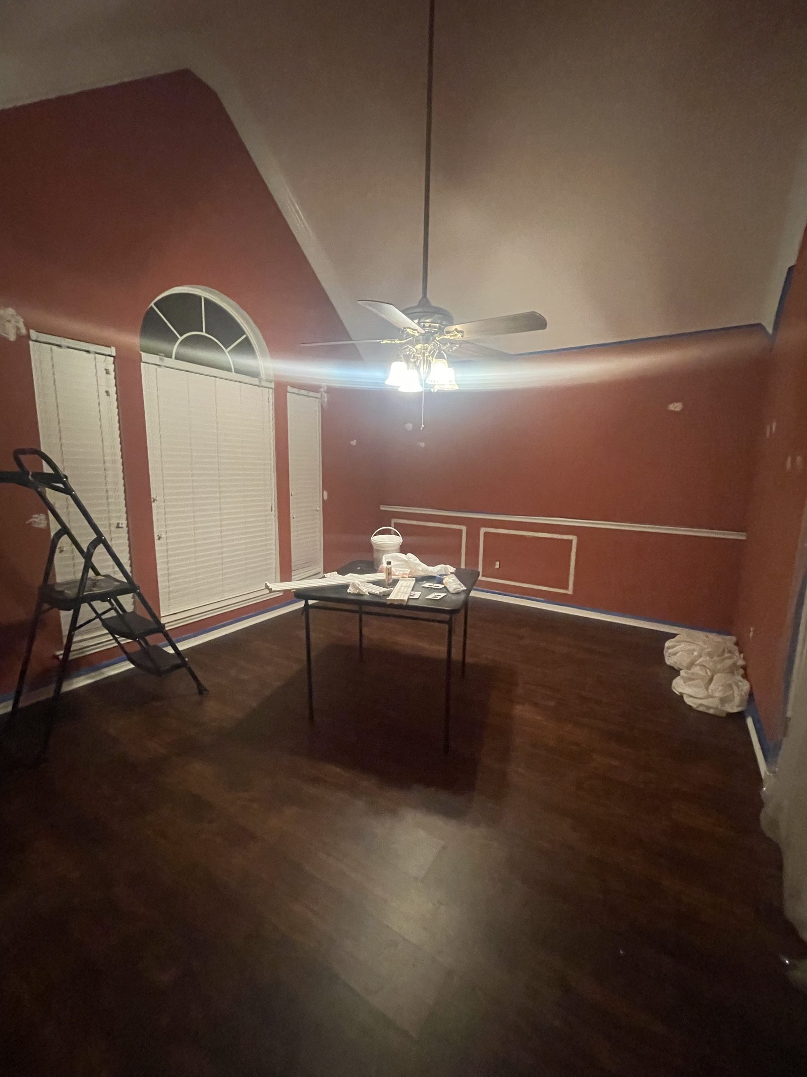 Dining room before, painted maroon with blue painter's tape applied