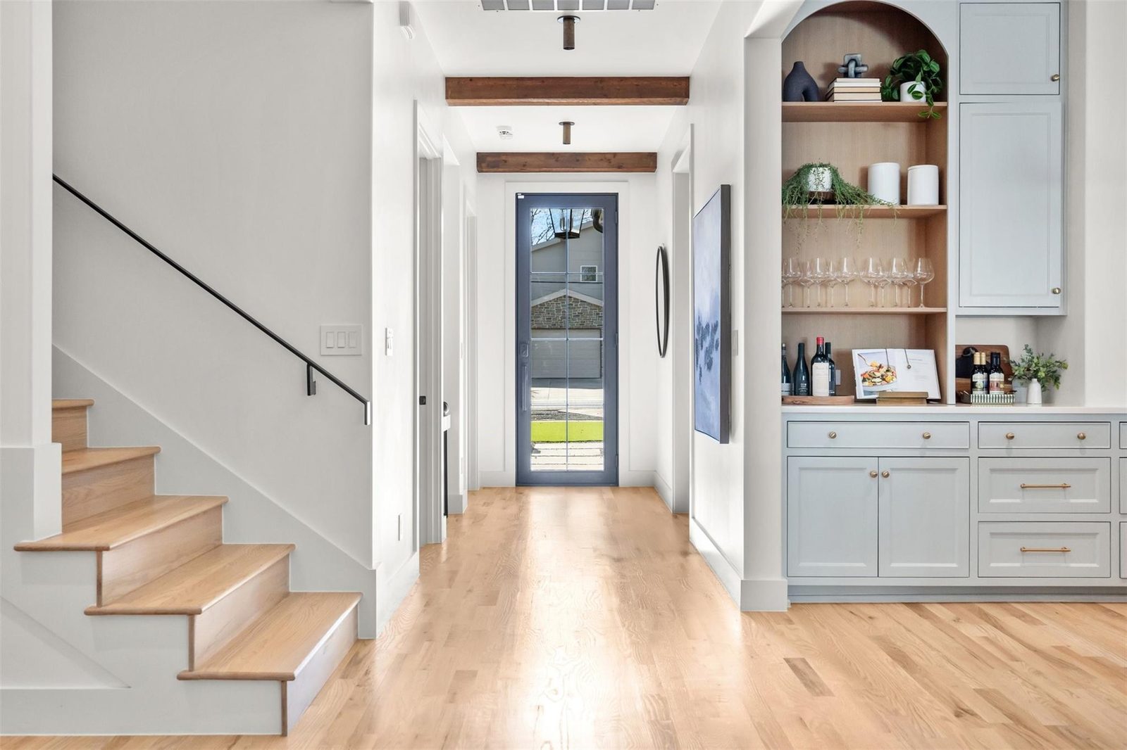 Entry hall with staircase and built-in bar cabinetry