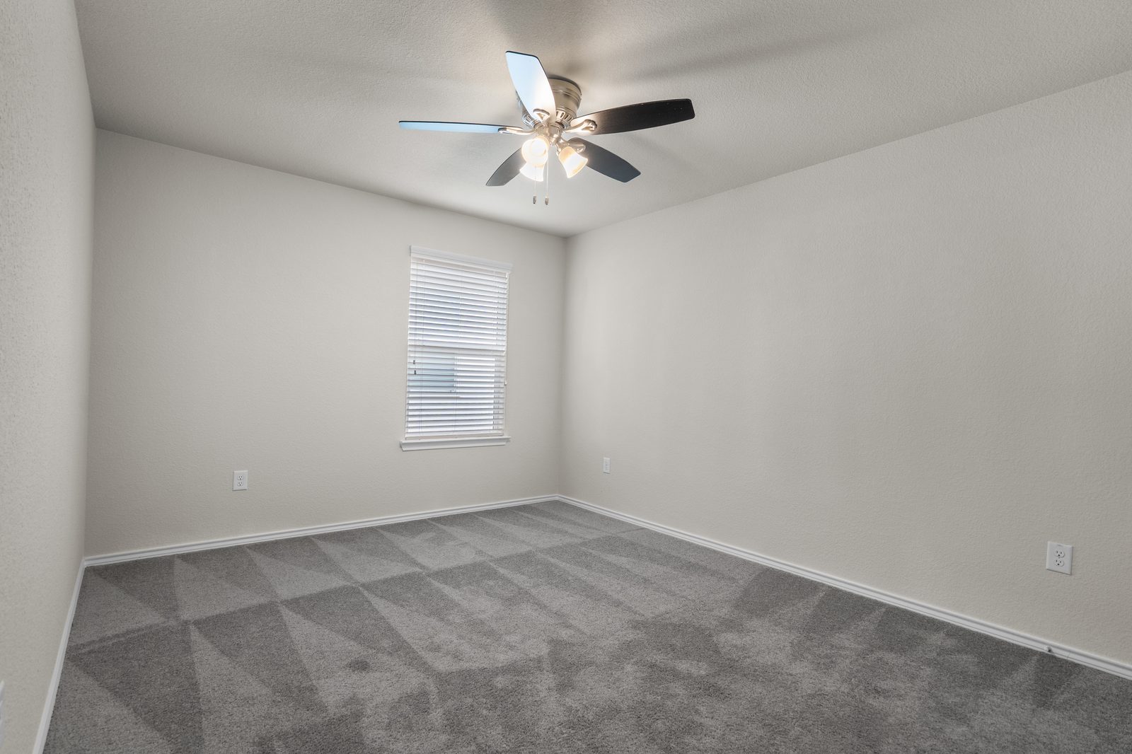 The same bedroom empty with grey carpet